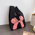 Knitted wrist tote bag in black with a large pink bow design and single handle strap - 20*35cm / Black and Pink Bow