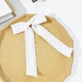 Detailed view of white ruffled bow hair clip with long ribbons in an elegant tray - White