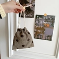 Detail of brown corduroy drawstring pouch with polka dots held by hand in a minimalist set - Grey Polka Dot