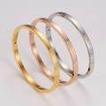 Dettaglio di tre braccialetti in acciaio inossidabile da 4 mm con motivi a onde incisi - Acciaio+Oro+Oro Rosa