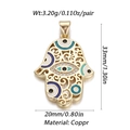Detail of golden Hamsa hand pendant with blue enamel eye and filigree metal work - Gold Hollow Hamsa Hand Charm