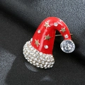 Macro view of Christmas hat brooch with red enamel, gold stars and white rhinestones - Gold Christmas Hat