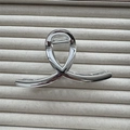 Dettaglio di una pinza per capelli in metallo argento con design a torsione lucida - Incrocio Medio Argento 11cm