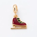Macro-opname van gouden schaatshanger met rood en groen email voor kerstsieraden - Schaats