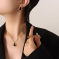 Gouden sieradenset met kattenoog hanger ketting en oorbellen gedragen door een model - Oorbellen / Goud Zwart Kattenoog Oorbellen