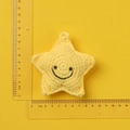 Detailed size measurement of a handmade yellow crochet starfish keychain with ruler - Yellow Knitted Smiley Starfish