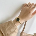 Elegant gold open bangle watch for women with a minimalist round black dial and metal mesh strap - No Scale Gold Band Black Dial