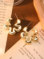 Detail shot of irregular gold wave earrings on vintage book pages background - Gold Flower