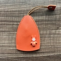 Orange leather key cover with 3D cartoon bunny and yellow heart detail on wood background - Rabbit - Orange