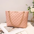 Rosa gesteppte Schultertasche mit goldener Kette auf weißem Strickstoff - Rosa