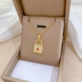 Macro view of gold heart lock pendant with red gemstone and sparkling cubic zirconia stones - Red Heart Lock Style (J110)