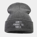 Detail of dark grey knit beanie with white Don't Forget To Smile embroidery on the cuff - Dark Gray
