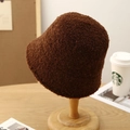 Primer plano detallado del tejido de forro polar marrón oscuro de un gorro de invierno - café