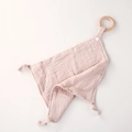 Detalle de una mantita de apego de muselina rosa para bebé con aro de madera natural - Rojo Almendra