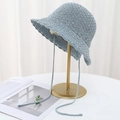 Close-up of blue crochet sun hat featuring honeycomb knit texture and lace-up ties - Light Blue