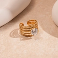 Macro shot of gold layered ring with heart zircon stone on warm stone background - Gold Heart Multi Layer
