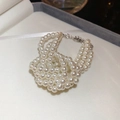 Detail van de drielaagse parelarmband set in een luxe wit fluwelen sieradendoosje - Meerlaagse geknoopte parelarmband / Wit