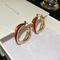 Vue macro détaillée de boucles d'oreilles doubles anneaux dorés avec émail rouge sur boîte - 67# Boucle-Or-Rouge