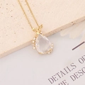 Vue détaillée du pendentif ange doré avec cristal en forme de goutte et chaîne fine - Blanc
