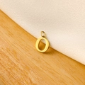 Macro shot of a polished gold letter O charm pendant on white fabric background - 14k Letter - O (letter Height 1cm)