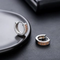 Vue macro de boucles d'oreilles huggie argentées avec gemmes oranges et zircons - Argent Zircone Orange