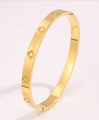 Gold-plated titanium steel bangle featuring five hollowed clover motifs with a polished finish - Embossed Clover / Gold