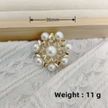 Vintage golden star brooch with pearls and rhinestones on white knit fabric - KC Gold Seven-Petal Flower