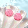 Macro-opname van roze glitter schelpen in een iriserende schaal boven water - Roze