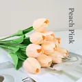 Set of ten artificial PU tulips in nude pink displayed on a desk with a magazine - Nude Pink