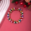 Weihnachtliches Perlenarmband mit bunten Glocken und Perlen auf festlichem rotem Grund - Perle mit bunten Glocken Stil-D1138