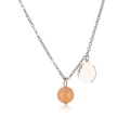 Macro detail of silver stainless steel chain with round stone and flat metal pendants - Steel Yellow Chalcedony
