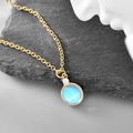 Minimalist gold necklace featuring a round celestial blue moonstone and zircon accent - Opal