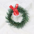 Détail d'une couronne de Noël en PVC vert ornée d'un ruban rouge brillant élégant - Anneau de pin vert de 8cm avec nœud