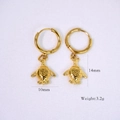 Polished 14K gold turtle charm hoop earrings with detailed shell texture on white fabric - Sea Turtle