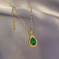 Detalle de collar de acero dorado con piedra de gota verde sobre seda gris suave - Cadena Dorada Colgante De Gota De Agua Verde (J513)