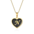 Macro view of golden heart pendant featuring black enamel and cursive letter N detail - Letter N Style