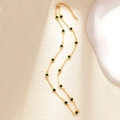 Detail of a gold plated necklace with small green heart charms on a textured background - A0157 Emerald Heart Chain