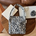 Dettaglio della mini borsa tote in tela ricamata con motivo a uccelli ed etichetta - Beige