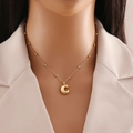 Nahaufnahme der goldenen C-Buchstabenkette mit Perlenkette am Hals eines Models - Buchstabe C