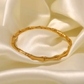 18K gold plated stainless steel bamboo joint bangle on white silk background - Gold