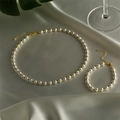 Elegant pearl and gold bead jewelry set displayed on silk with soft natural lighting - Set - Pearl & Gold Bead