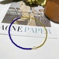 Close-up of blue beaded necklace with a baroque pearl and gold adjustable chain - Blue Cut Bead Pearl Splicing