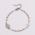 Macro-detail van de tweekleurige kralenarmband met kruishanger en religieuze medaillon - 17+3cm / Goud & Zilver