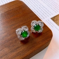Vista macro de pendientes de flor con piedra central verde y circonitas brillantes - Plata (Pin de plata)