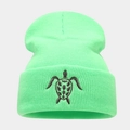 Close-up of a neon green knit beanie featuring a black turtle embroidery on the cuff - Fluorescent Green