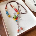Collier ethnique en perles de céramique avec pompons colorés et détails argentés - Gland en Céramique Coloré