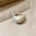 Detailed view of a cream white domed resin ring on a textured linen background - 33# Ring - White - Domed Resin