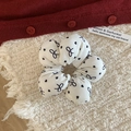 White sponge scrunchie with black heart and bow pattern on a textured background - White Base Black Bow