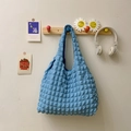 Blue pleated puff cloud handbag featuring a unique 3D grid texture hanging on a wooden hook - Blue