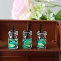 Detailed macro view of three miniature lemon drink bottles with straws and fruit slices - Fruit Cup 10